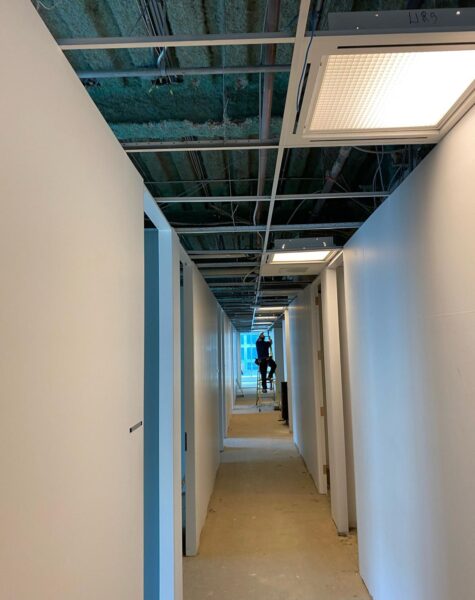 Travaux d'installation de luminaire dans un bureau en construction