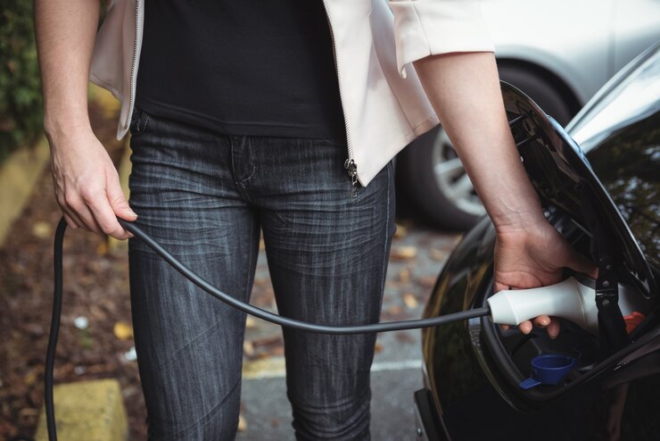 woman charging electric car